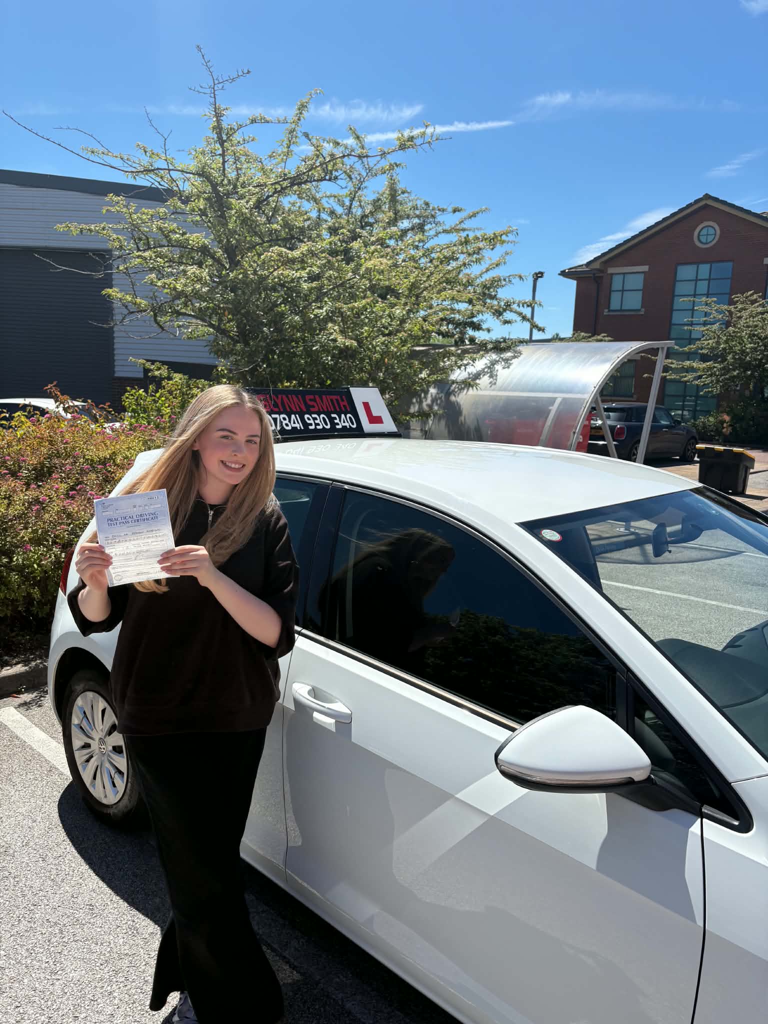 Daisy beside a car, holding a document.